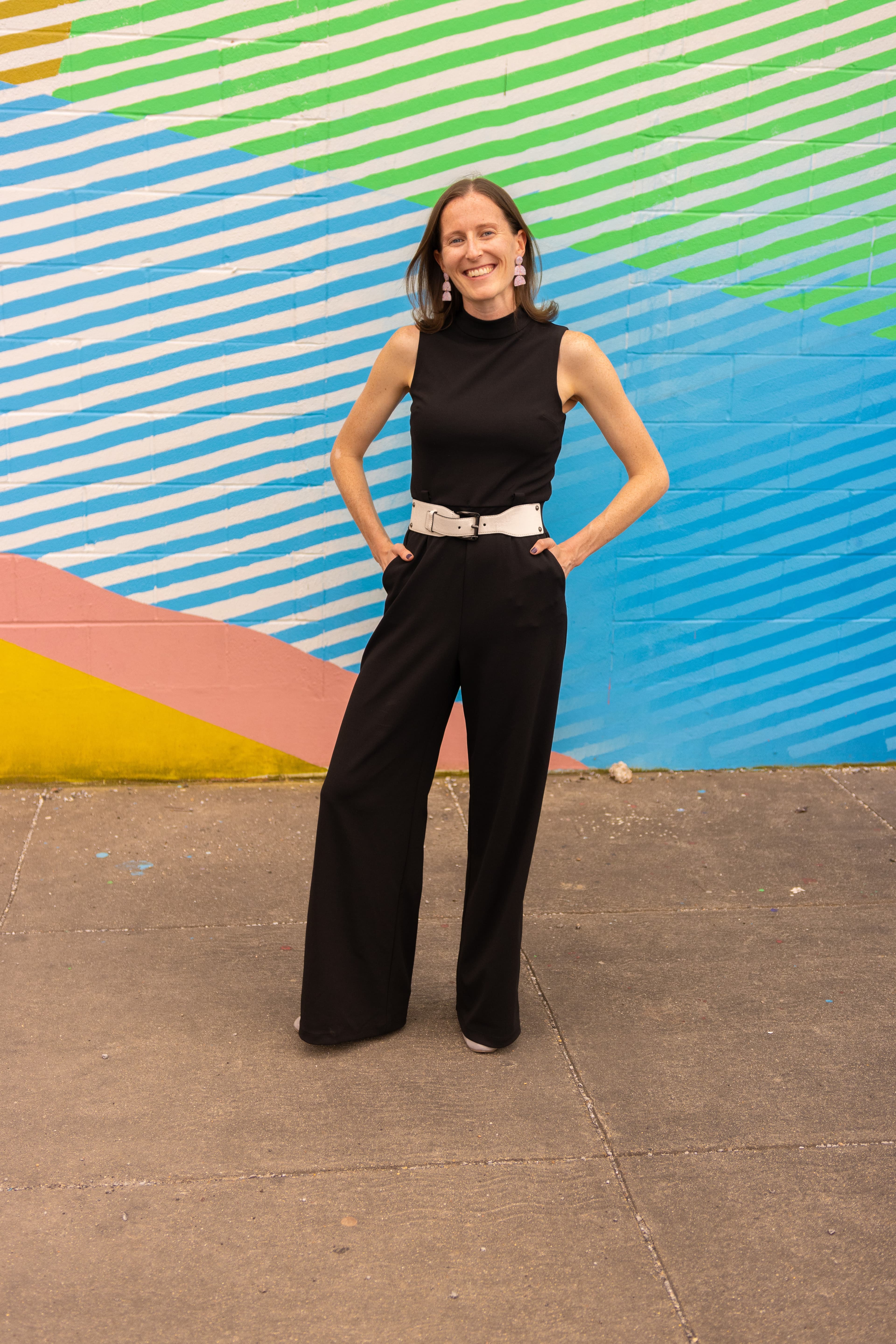 Lauren Jewett standing in front of a colorful mural.